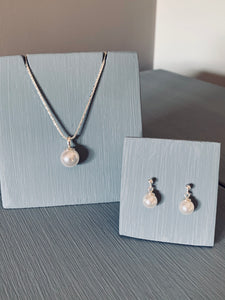  classic Pearl jewellery set. Each piece features lustrous 10mm pearl gracefully adorning a sterling silver 18-inch chain necklace, paired with delicate drop earrings boasting 6mm pearls. 